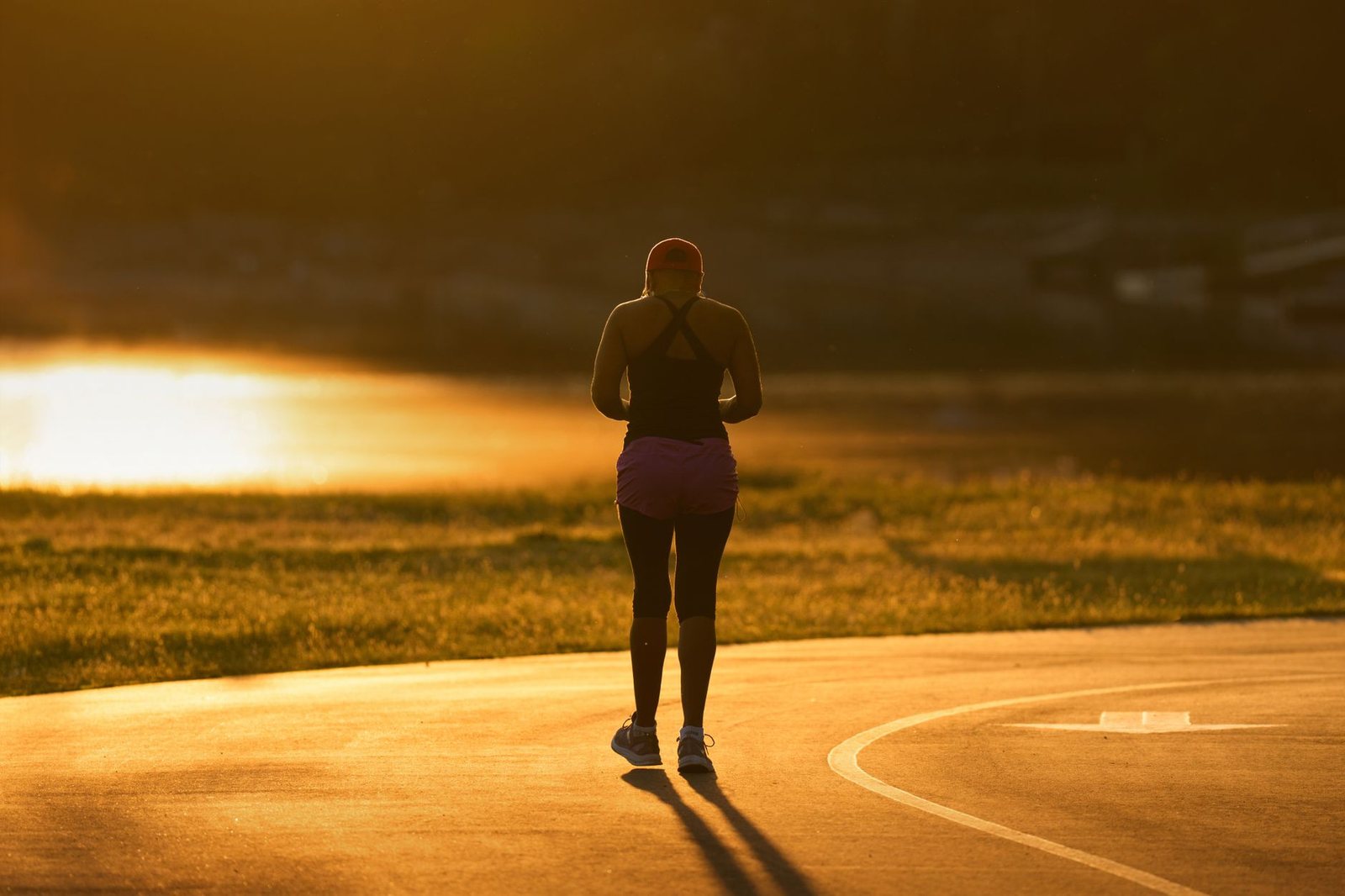 Corredor entrenando en pista al atardecer