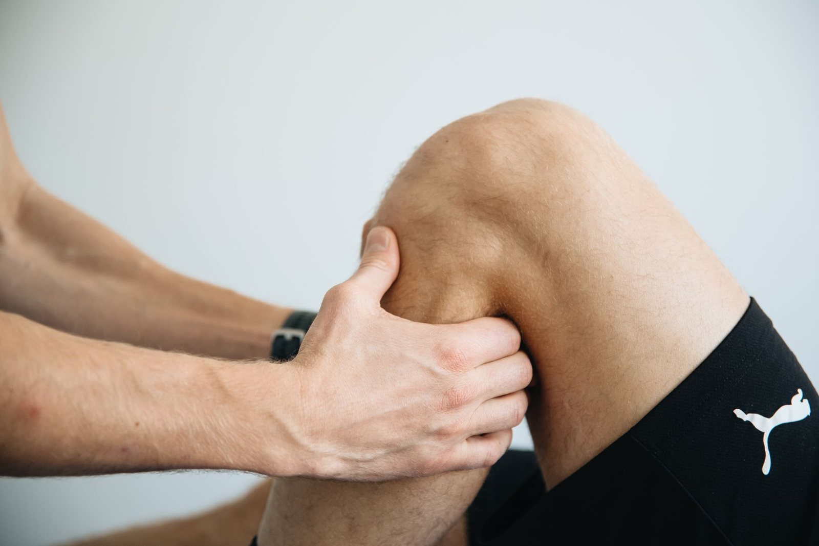 Terapeuta trabajando la rodilla de un paciente deportista